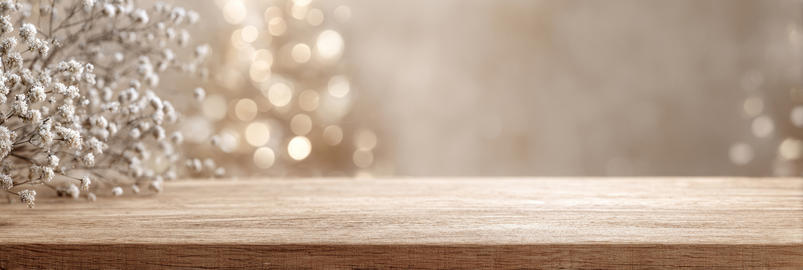 Wooden table with white flowers and soft golden bokeh background