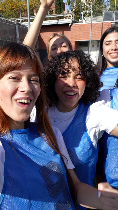 Female sports team celebrating victory taking selfie