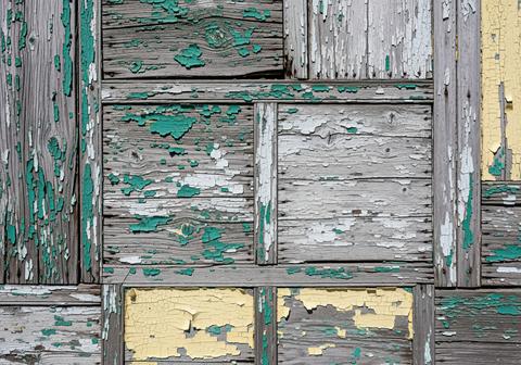 Distressed wooden mosaic pattern with peeling teal, white, and yellow paint texture