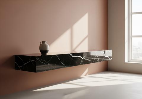 Modern floating black marble shelf with a vase against a pink wall and natural sunlight