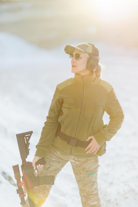 Female soldier holding rifle posing in snowy mountain