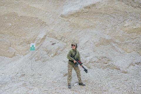Female soldier holding rifle in snowy landscape