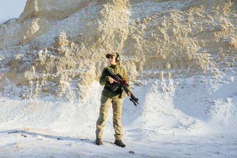 Female soldier holding a rifle during military training in winter