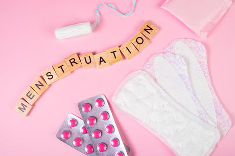 Sanitary pads, tampons, pills on pink background. Feminine hygiene products for menstruation