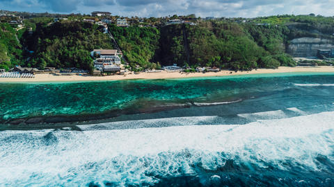 Scenic tropical coastline with cliffs and blue ocean with waves in Bali. Aerial view