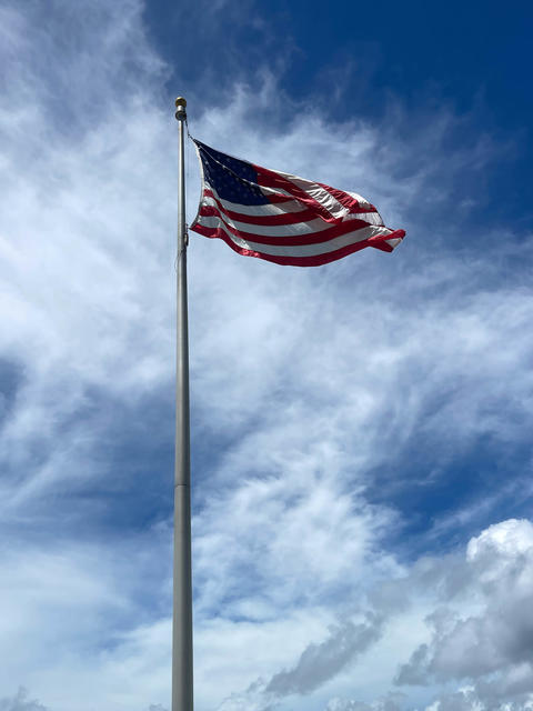 American flag with sky and clouds background