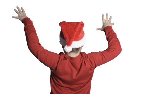 A boy in a Santa suit with his back to the camera Wave your arms like an orchestra conductor