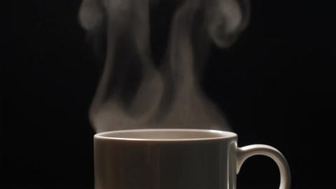 Steam Rising from White Coffee Cup. Black Background