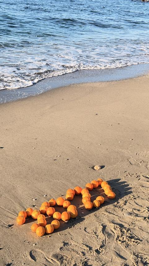 Oranges, New Year's decorations on the beach. Christmas by the sea