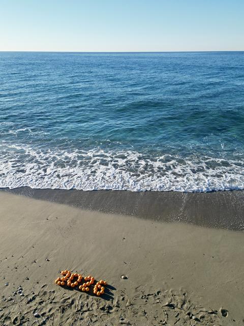 Oranges, New Year's decorations on the beach. Christmas by the sea