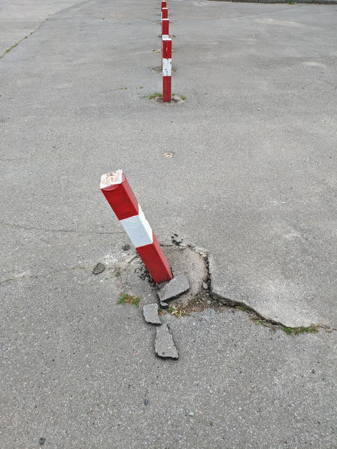 The barrier post for cars is broken. The iron traffic barrier poles with red and white color