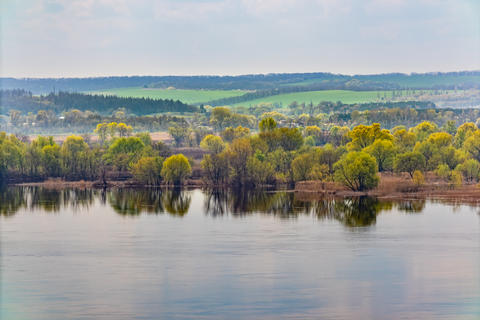 Spring landscape of the banks of the Dnieper river (Dnipro) from a height. Trees and fields