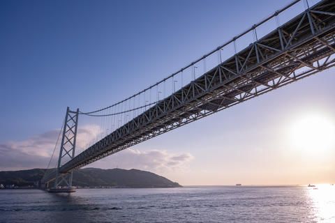 Suspension Bridge Over the Sea at Dusk with Natural Landscape