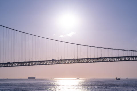 Suspension Bridge Over the Sea at Sunset with Calm Ocean