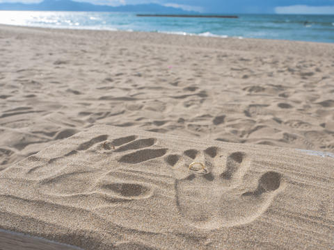 Handprints with Rings on Sandy Beach and Ocean View