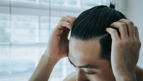 Japanese man checking his scalp (self-care/hair loss prevention)