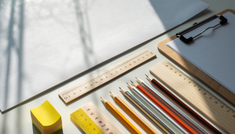 A minimalist overhead view of a clean white background and wooden stationery