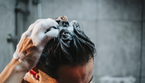 Close-up of a man caring for his scalp with shampoo