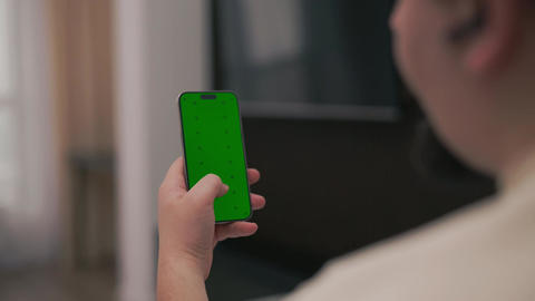Person using a smartphone with green screen