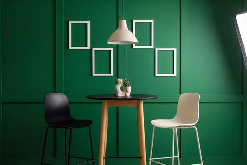 Modern cafe corner with small table two chairs and green wall