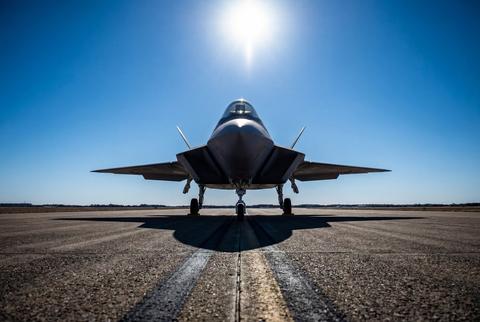 Sleek stealth fighter jet on airfield under bright sun