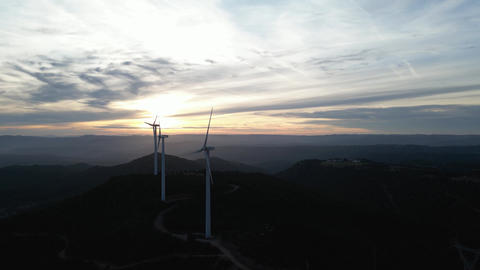 Wind turbines generating renewable energy at sunset