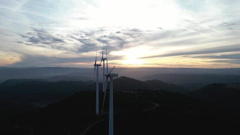 Drone footage of wind turbines with a mountainous landscape