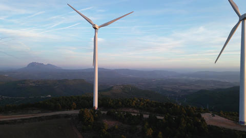 Wind turbines producing green energy during sunset
