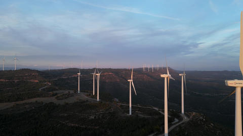 Aerial view of wind turbines generating renewable energy at sunset