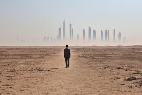 Person in Smart Jacket Standing in an Open Field with City Skyline in Background