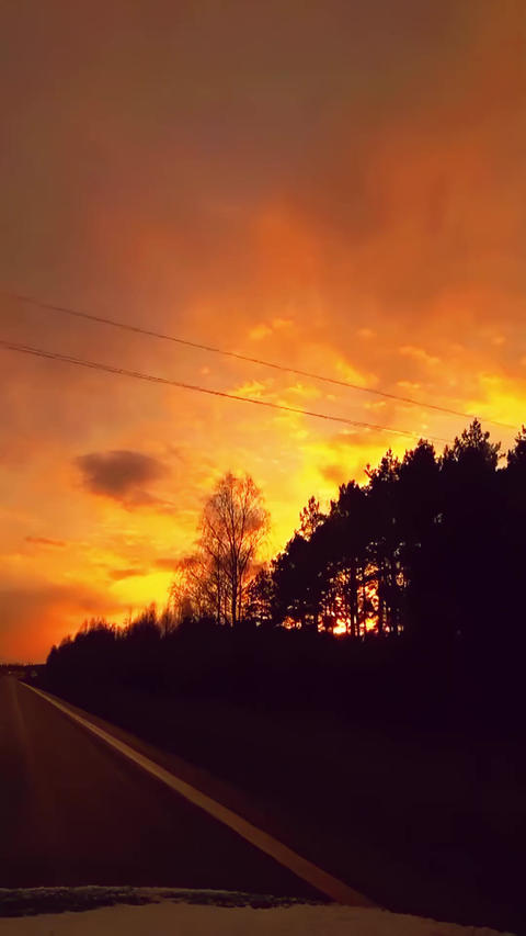 POV drive along empty road at sunset with glowing sky