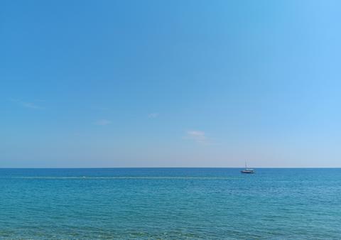 Distant view of the Aegean Sea with a small boat, Greece