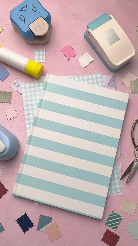 Crafting supplies and journal on pink desk