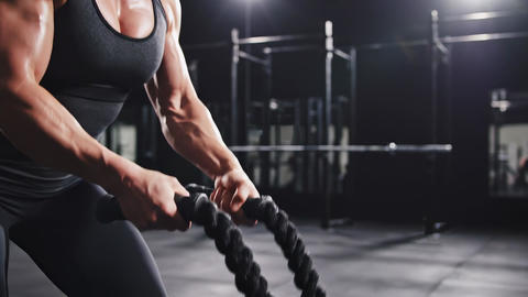 Athletic man lifting weights in a dark gym