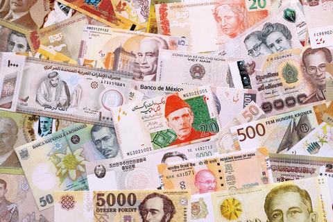 Various currencies money bills banknotes in yellow and orange color. Many cash bills