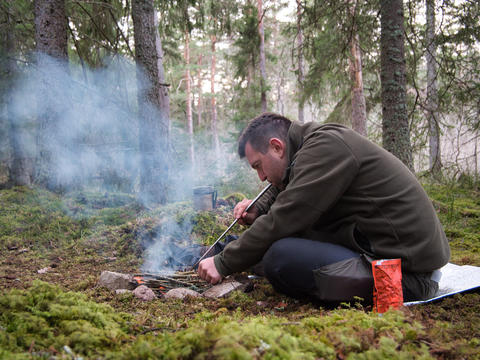 Man making fire in forest camping Sweden outdoor survival