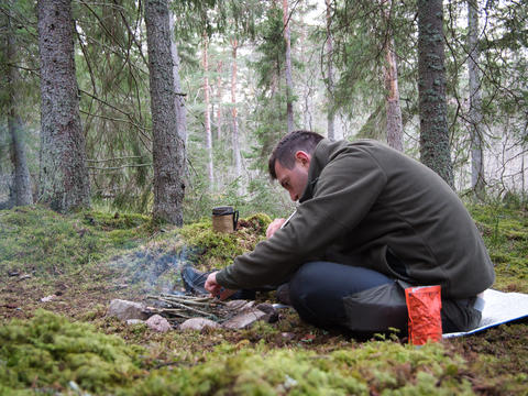 Man making campfire in forest camping Sweden outdoor