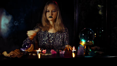 Mystical fortune telling ritual with a woman psychic crystal ball candles smoke