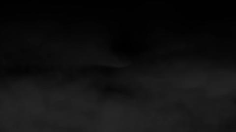 Dark smoke slowly drifting and swirling on black background. Abstract fog motion