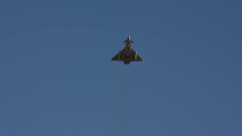 Military fighter jet head on view in blue sky slow motion