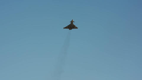 Military fighter jet climbing vertically with engine smoke slow motion