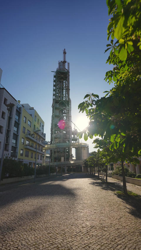Gasometer tower rising above Lisbon cobblestone street
