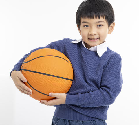 Happy boy holding fbasketball with his hands