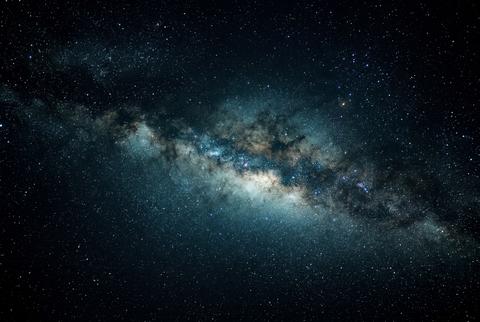 Glowing milky way galaxy stretching across a dark starlit night sky in deep space