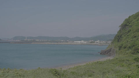 Japan's coastline, a tapestry woven from calm seas and lush green mountains