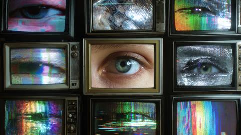 Surveillance concept with human eye on vintage TV screens and glitch effects