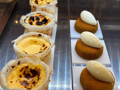 Assorted cream filled pastries with topping arranged on display trays. Bakery assortment, dessert