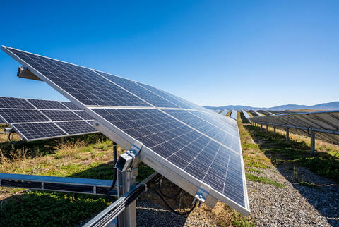 Array of modern solar panels angled towards a blue sky