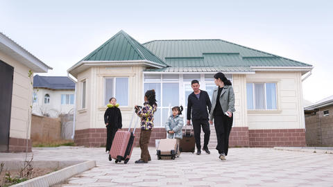 A big family is going on vacation. A Kyrgyz family of five leaves their house with suitcases. The