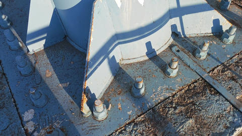 Abandoned ferris wheel structure with rusty bolts and peeling paint against